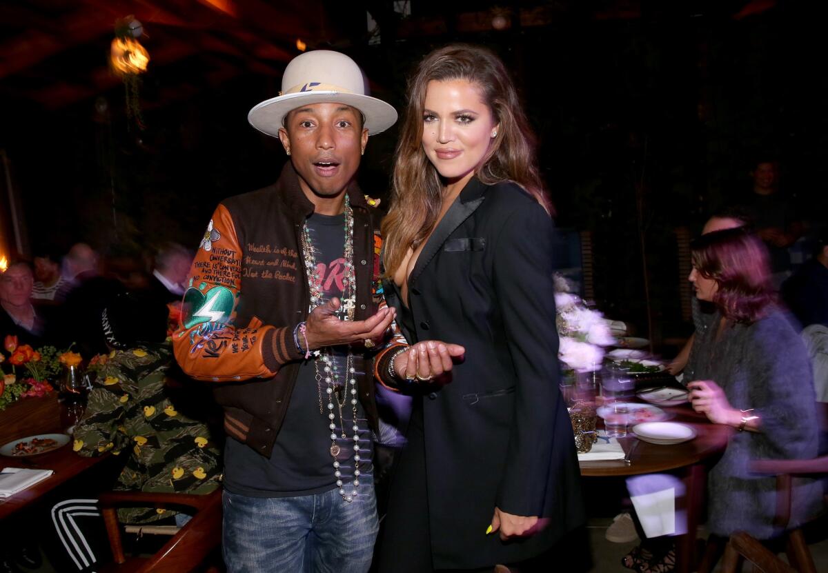 Khloe Kardashian poses for a photo with Pharrell Williams at an event early this month marking his collaboration with Adidas.