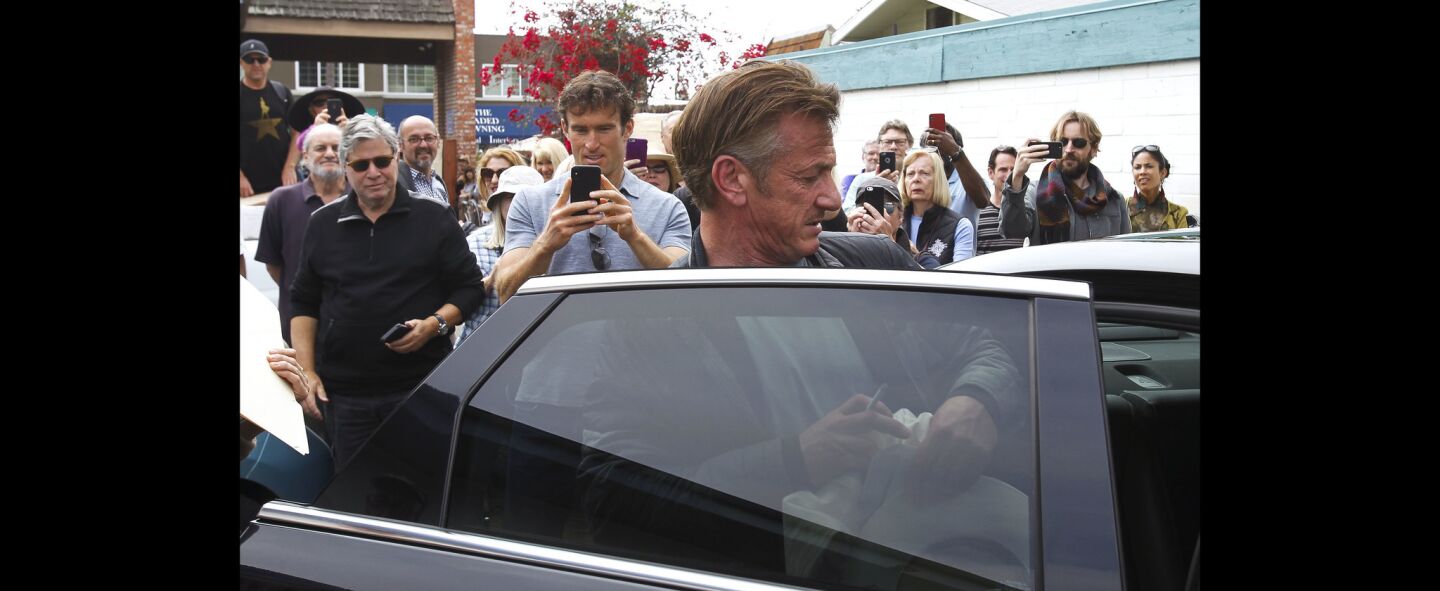 People take pictures as Sean Penn gets into a waiting car after promoting his new book 'Bob Honey Who Just Do Stuff' at D.G. Wills Books in La Jolla.