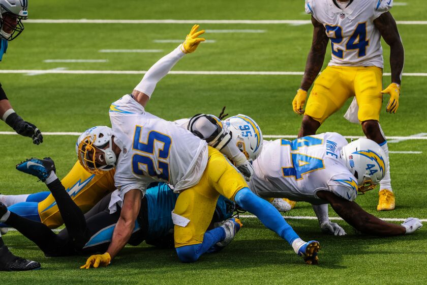 Inglewood, CA, Sunday, September 27, 2020 - Los Angeles Chargers cornerback Chris Harris (25) writhes in pain after injuring his leg while stuffing runner Carolina Panthers running back Mike Davis (28) at SoFi Stadium. (Robert Gauthier/ Los Angeles Times)