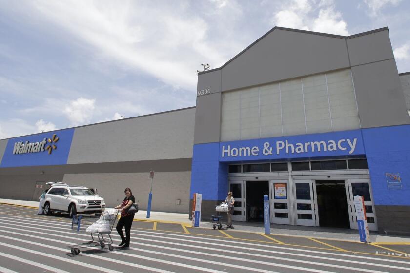 In this Thursday, June 1, 2017, photo, customers walk out of a Walmart store in Hialeah Gardens, Fla. Walmart is expected to provide an update about its expansion plans and issue an outlook for revenue and earnings at its annual shareholder meeting, Tuesday, Oct. 10, 2017. (AP Photo/Alan Diaz)