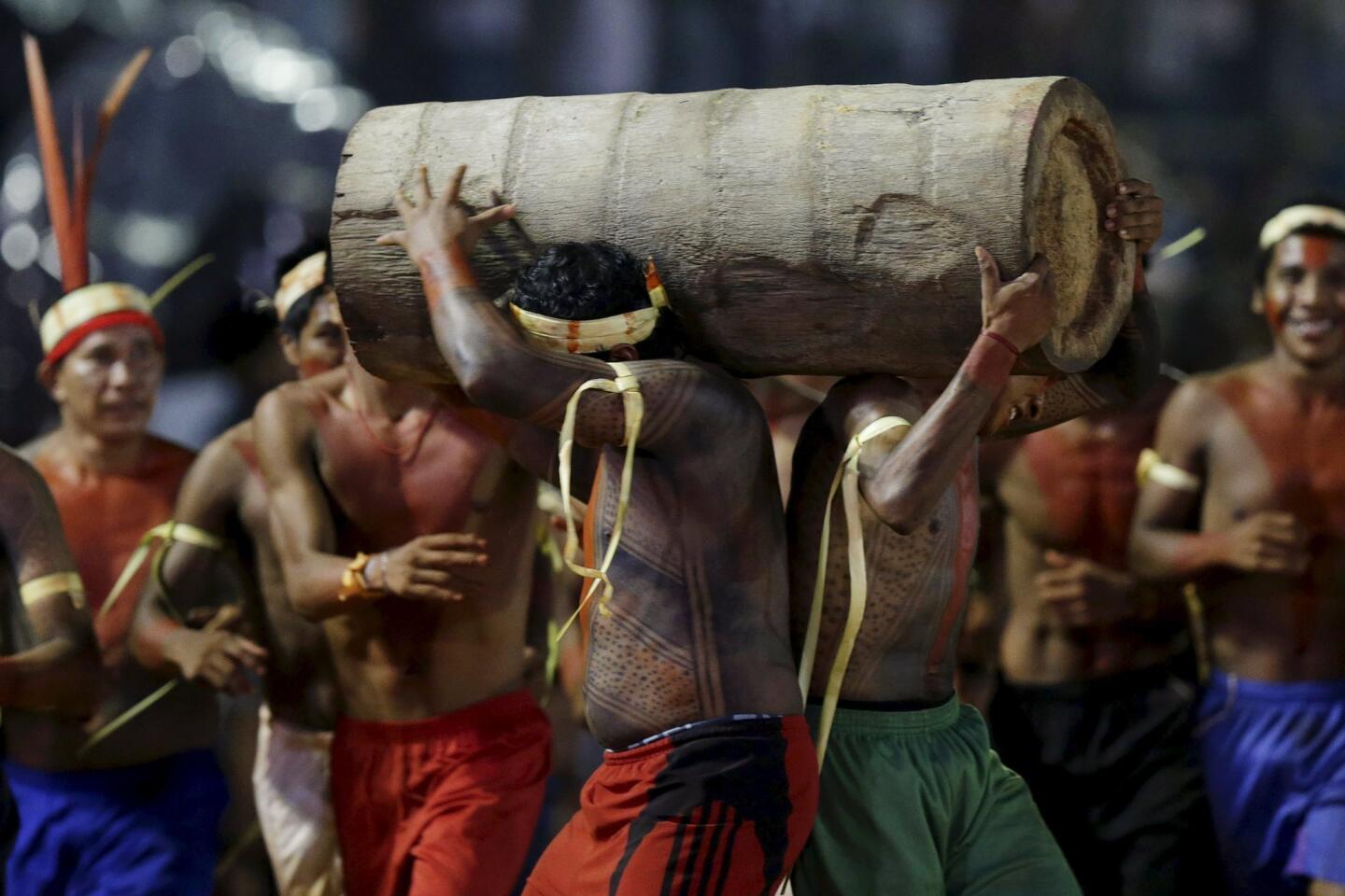 Indigenous men from the Xerente tribe compete in a relay race carrying tree trunks during the first World Games for Indigenous Peoples in Palmas