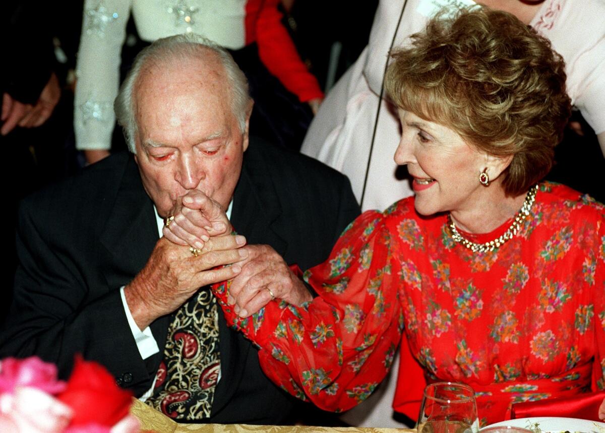 Bob Hope kisses Nancy Reagan's hand at the Ronald Reagan Freedom Awards in 1997.
