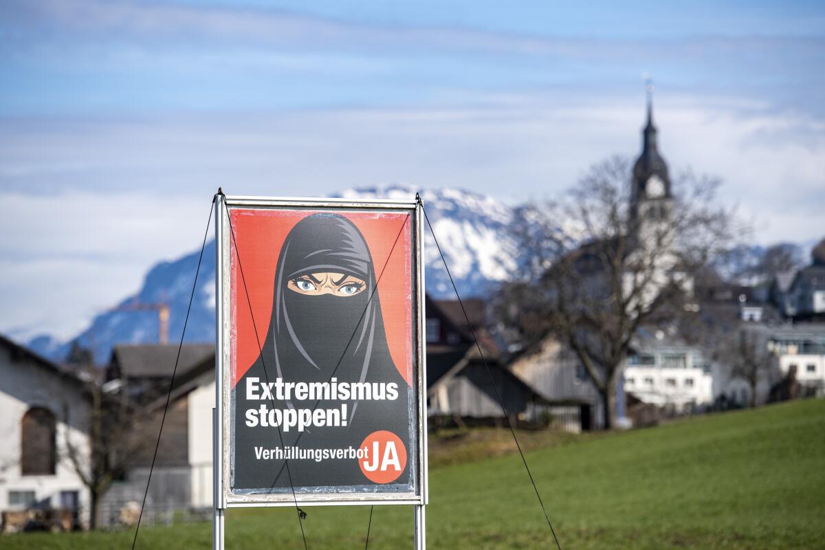 A poster supporting the initiative 'Yes to a ban on covering the face' shows a woman in a black niqab.