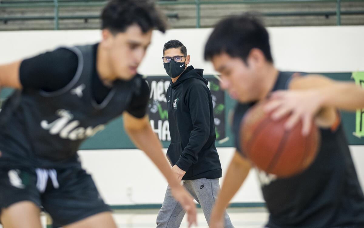 Jesse Mercado, the new boys' basketball coach at Costa Mesa High School, oversees player drills during practice on Friday.