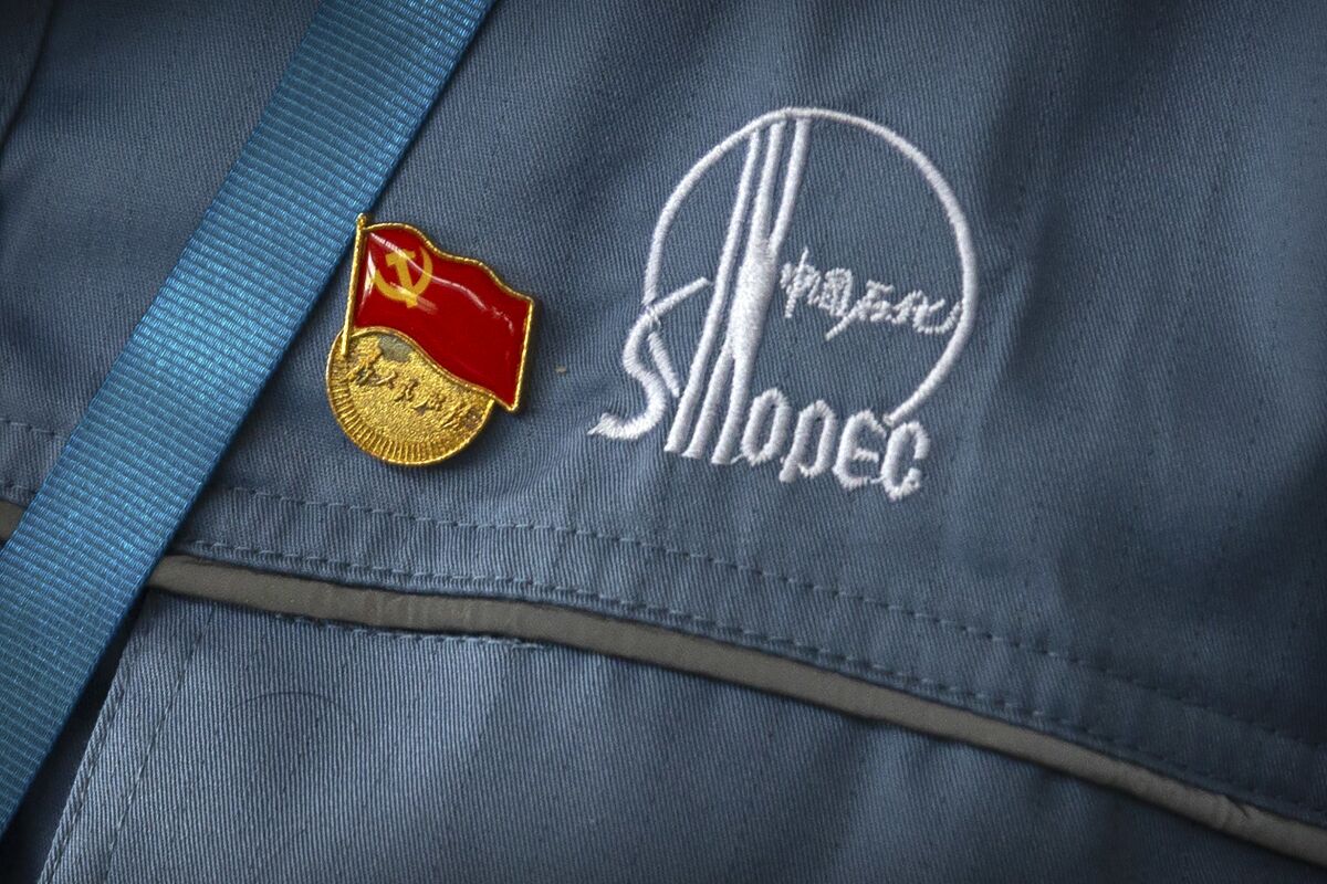 FILE - A Chinese Communist Party badge is pinned to a worker's uniform at the Sinopec Yanshan Petrochemical Company on the outskirts of Beijing on May 25, 2018. Three state-owned Chinese corporate giants announced plans Friday, Aug. 12, 2022, to remove their shares from the New York Stock Exchange amid a dispute between Washington and Beijing over whether U.S. regulators can see records of their auditors. PetroChina, China Life and China Petroleum & Chemical, widely known as Sinopec, said the shares affected were American depositary shares, or ADSs, that represent shares traded in Hong Kong. (AP Photo/Mark Schiefelbein)