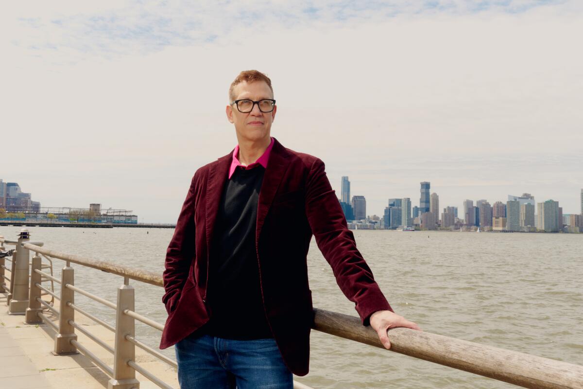  John Hoffman stands at Hudson River Park with the New York skyline in the background.