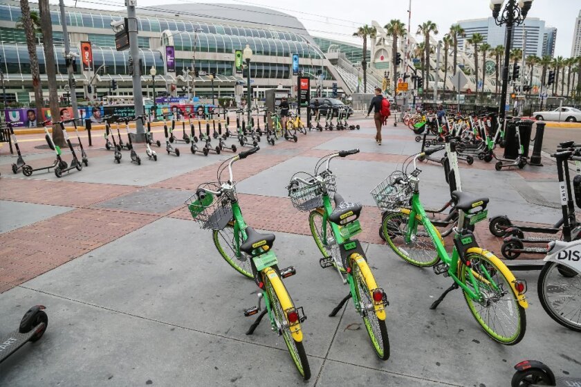 SAN DIEGO, CA July 10th, 2018 | All large number of rental bikes and scooters are parked near the Convention Center along 5th Ave. on Tuesday, possibly for the upcoming Comic-Con Convention in San Diego, California.