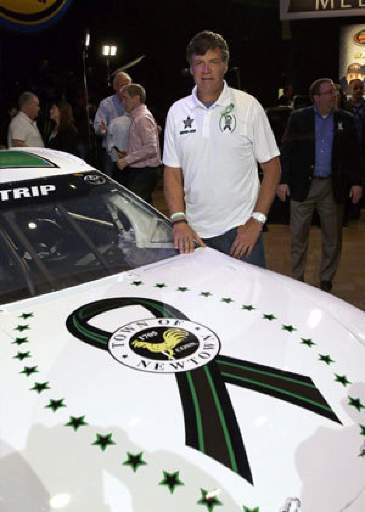 Michael Waltrip poses with the car he will drive in this year's Daytona 500.