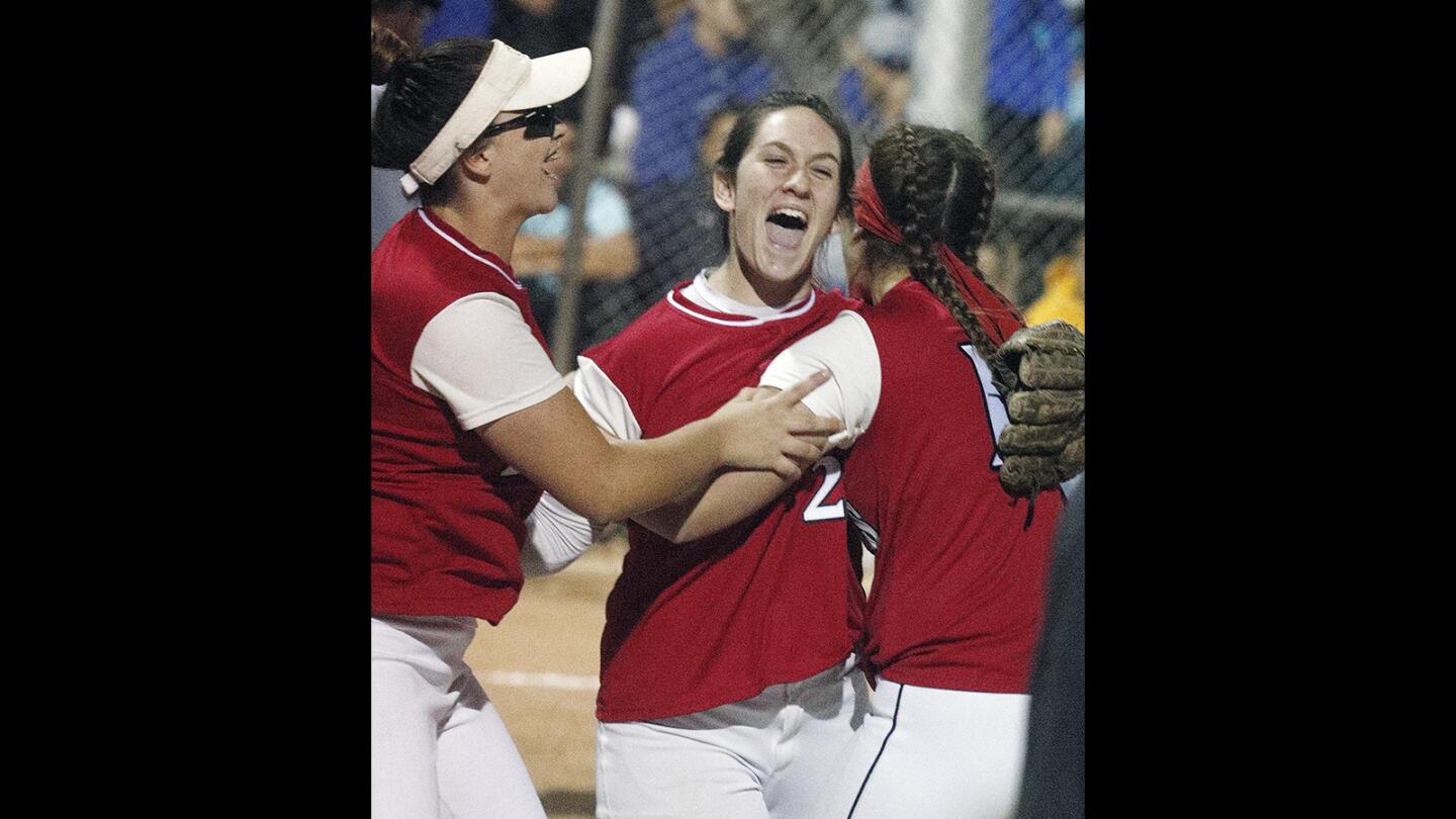 Winning pitcher Burroughs' Presley Miraglia celebrates with her teammates after defeating Burbank in a Pacific League softball game at McCambridge Park in Burbank on Thursday, April 12, 2018. Burroughs won the game 1-0.