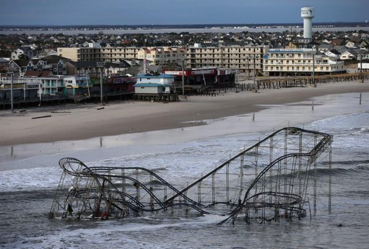 Waves break over a roller coaster wrecked by Superstorm Sandy last year on the East Coast.