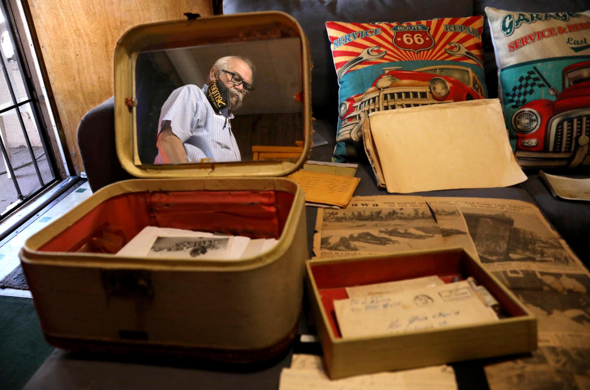 Isaac Cruz III is reflected in a mirror of a cosmetic case that contains letters and memorabilia from his uncle Jacob Cruz.