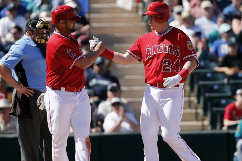 Albert Pujols, left, salutes Angels teammate C.J. Cron, who hit a two-run homer in the third inning at Tempe (Ariz.) Diablo Stadium.