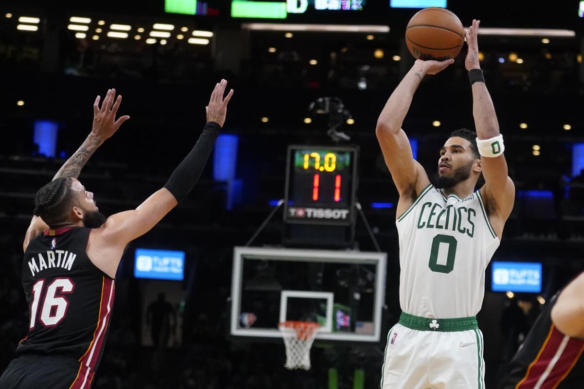 Boston Celtics forward Jayson Tatum shoots over Miami Heat forward Caleb Martin.