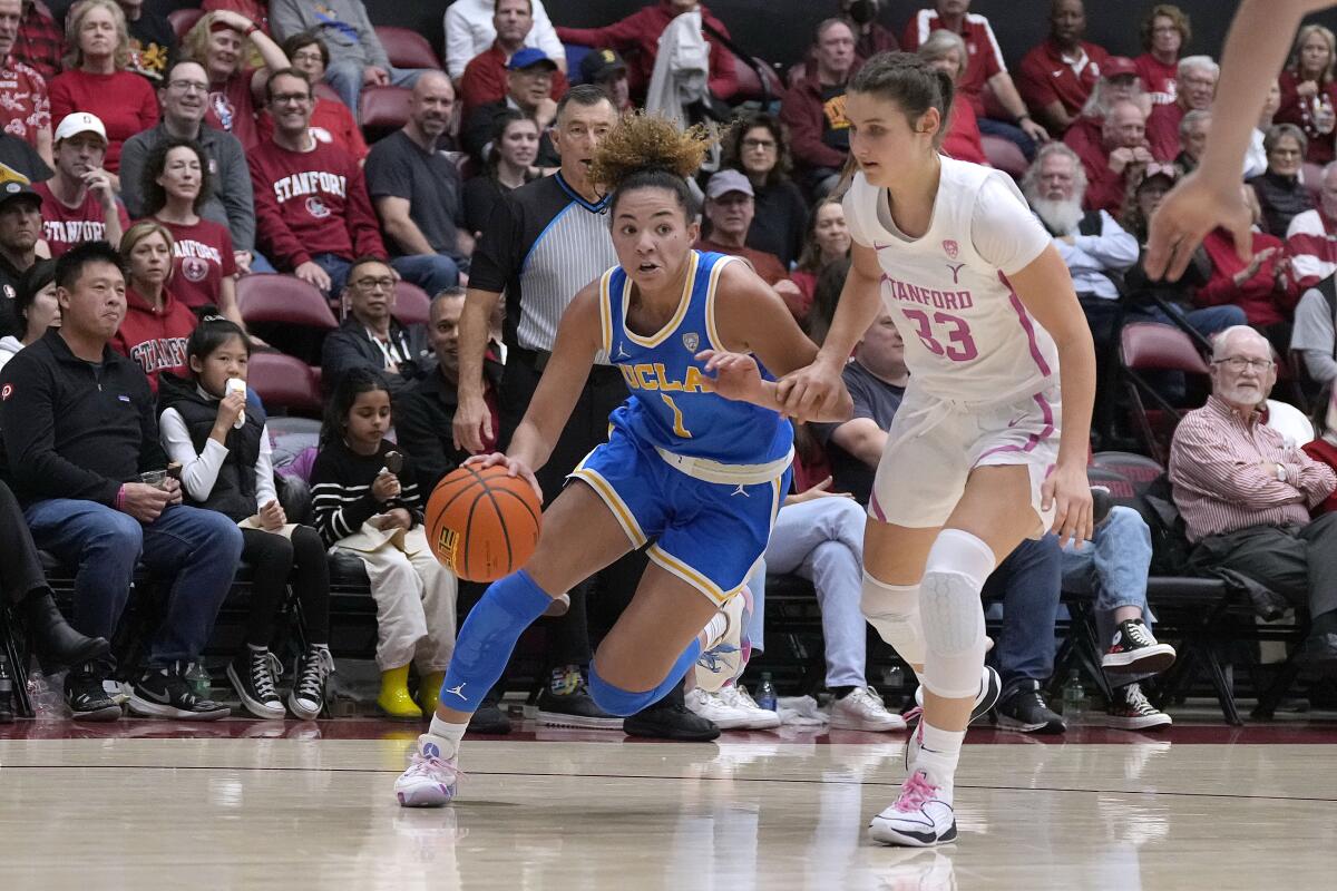 UCLA guard Kiki Rice drives to the basket in front of Stanford guard Hannah Jump.