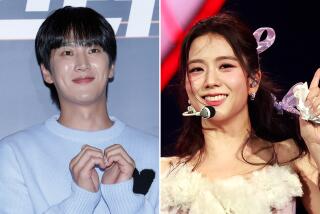 Ahn Bo-Hyun smiles and makes a heart shape with his hands; Jisoo smiles while wearing a headset microphone
