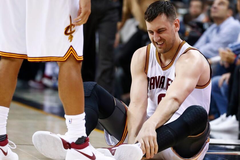 Cleveland's Andrew Bogut reacts after injuring his leg during a game against Miami on March 6.