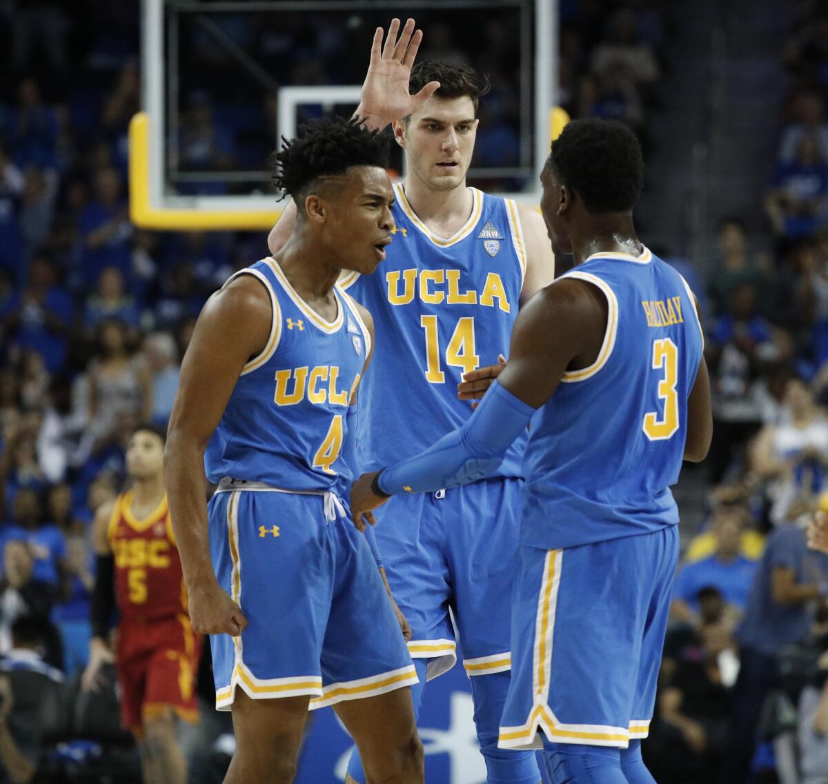 UCLA guard Aaron Holiday (3) is congratulated by guard Jaylen Hands (4) and forward Gyorgy Goloman (14) after sinking a three-point shot late in the game against USC at Pauley Pavilion on Feb. 3.
