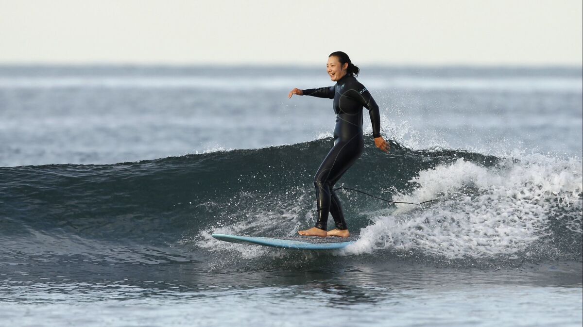 San Diego native Tiffany Joh is a veteran on the LPGA Tour, and an avid surfer, shown here Tuesday morning in Carlsbad. Joh will play at the Kia Classic this week at Aviara, but is glad to be home to catch some waves in between rounds.