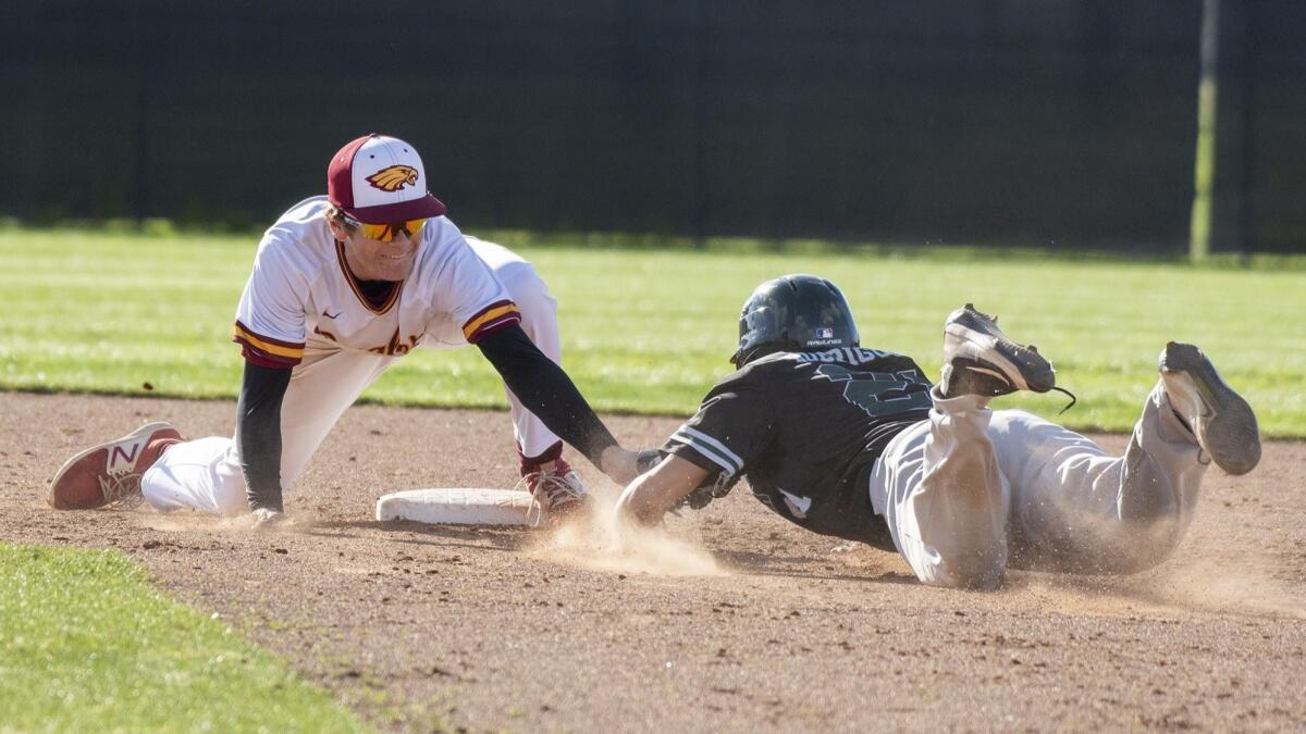 Estancia High's Jake Alai tags out Costa Mesa's Miguel Rodriguez on a stolen-base attempt during an Orange Coast League game on Friday.