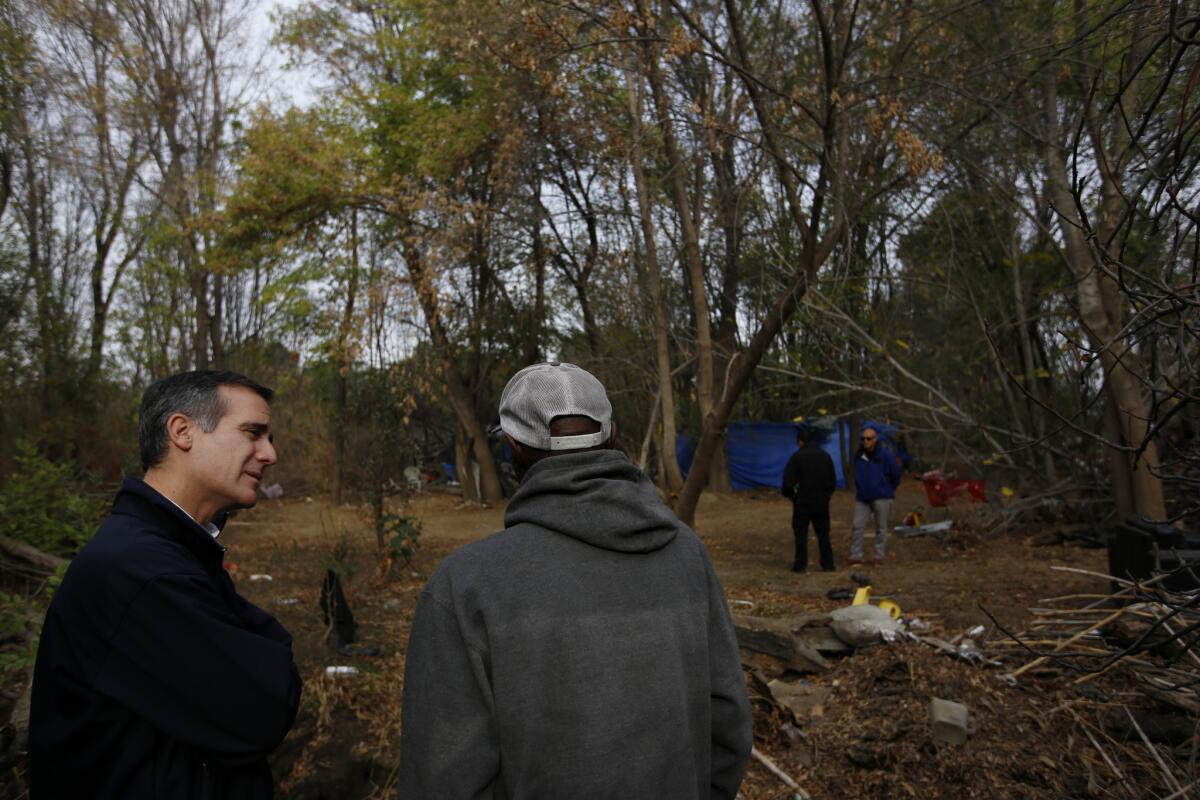 Mayor Eric Garcetti, left, visits a homeless encampment near the Sepulveda Basin in Encino in 2016.