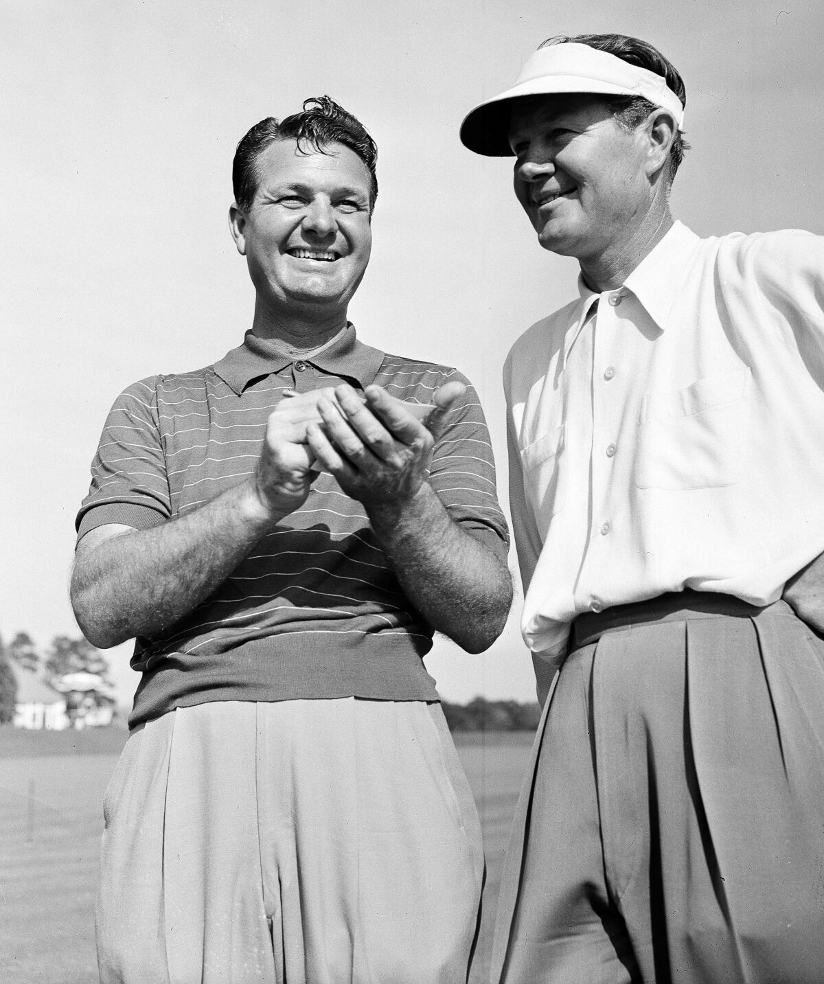 FILE - Jimmy Demaret, left, and Byron Nelson smile as they add up their golf score on the 13th green at Augusta, Ga., April 4, 1947, during the first round of the Masters. Demaret won the Masters 75 years ago. (AP Photo)