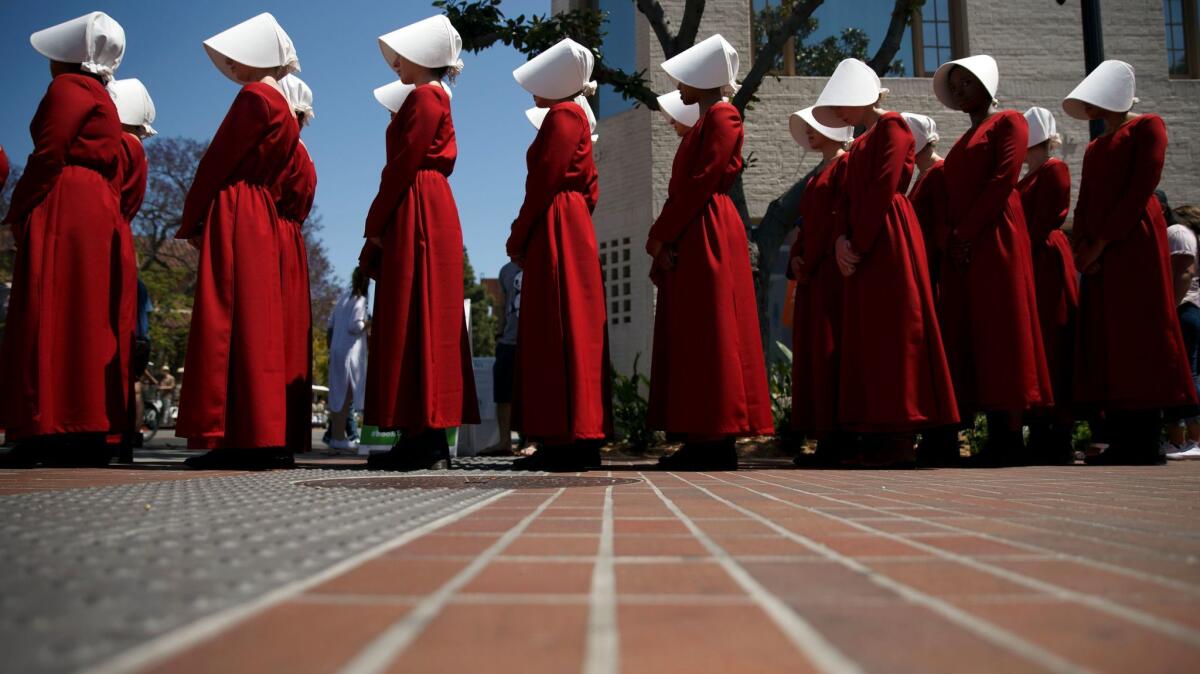Actresses dressed as Handmaids marketing Hulu's "The Handmaid's Tale" walk through the crowd at the Los Angeles Times Festival of Books. (Patrick T. Fallon / For The Times)