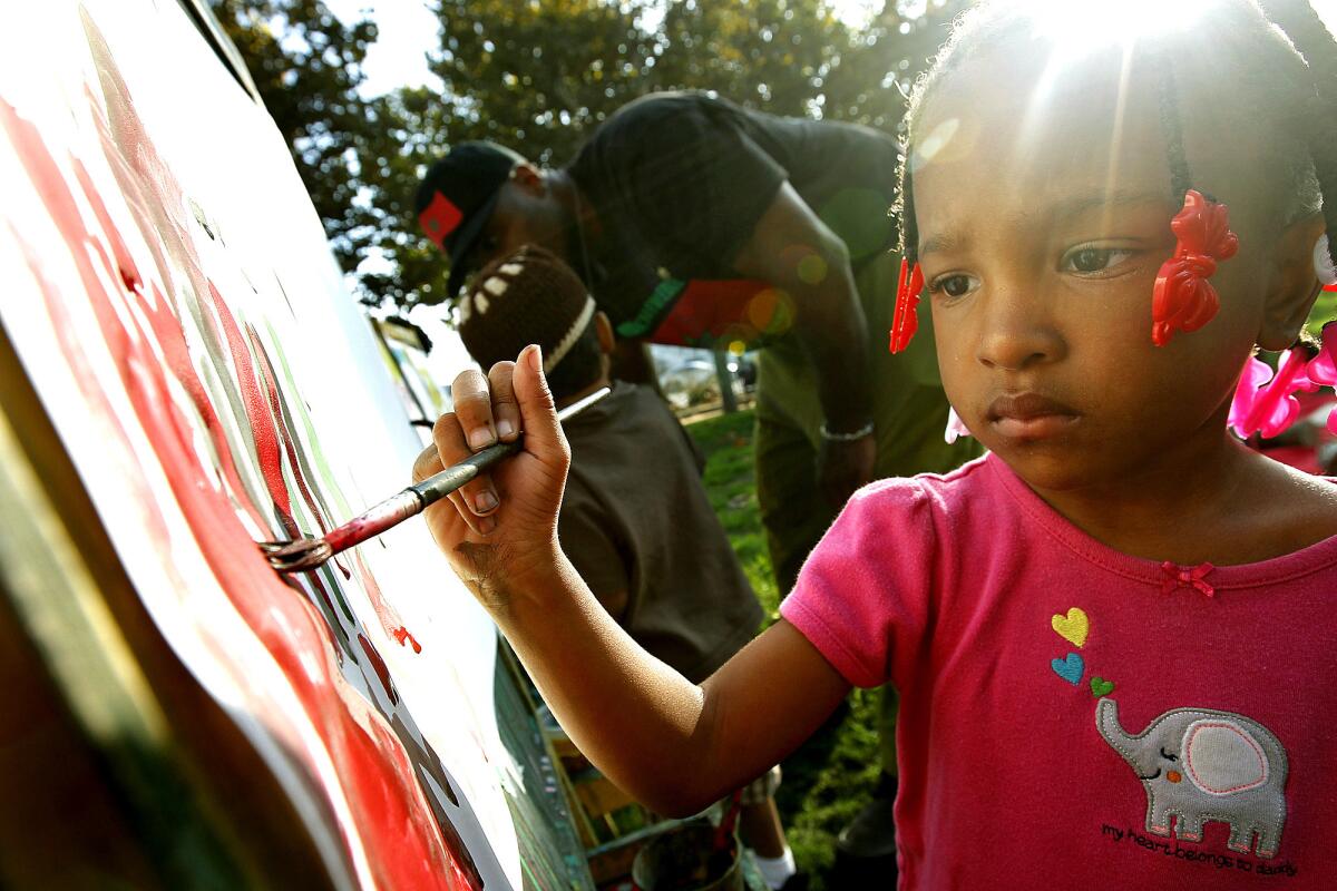 Phoebe Bennett, 3, paints in Leimert Plaza Park.