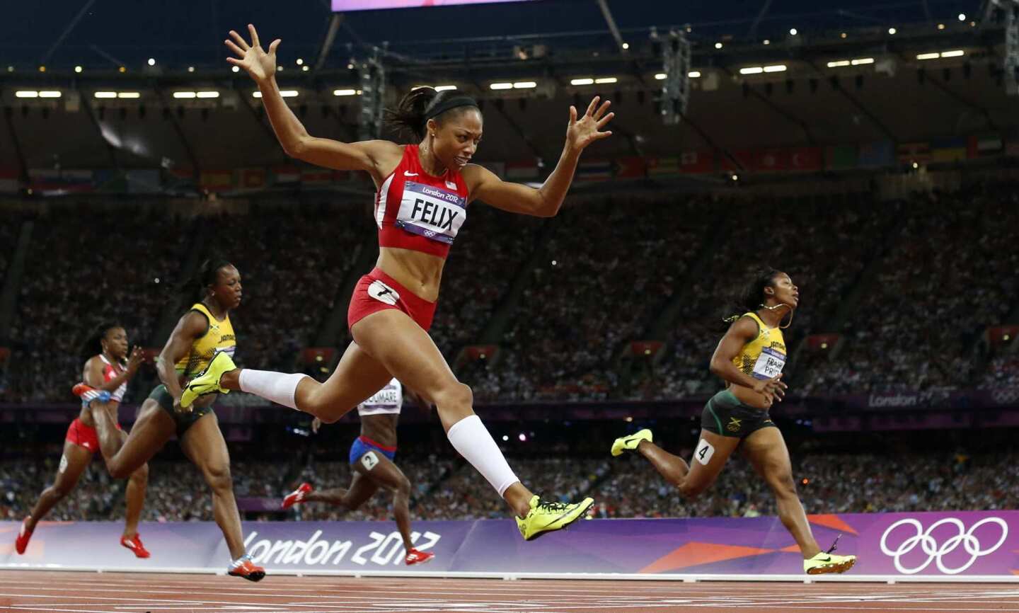 Team USA's Allyson Felix, center, crosses the finish line Wednesday to win gold ahead of Jamaica's Shelly-Ann Fraser-Pryce, right, in the women's 200-meter final at the London 2012 Olympics.