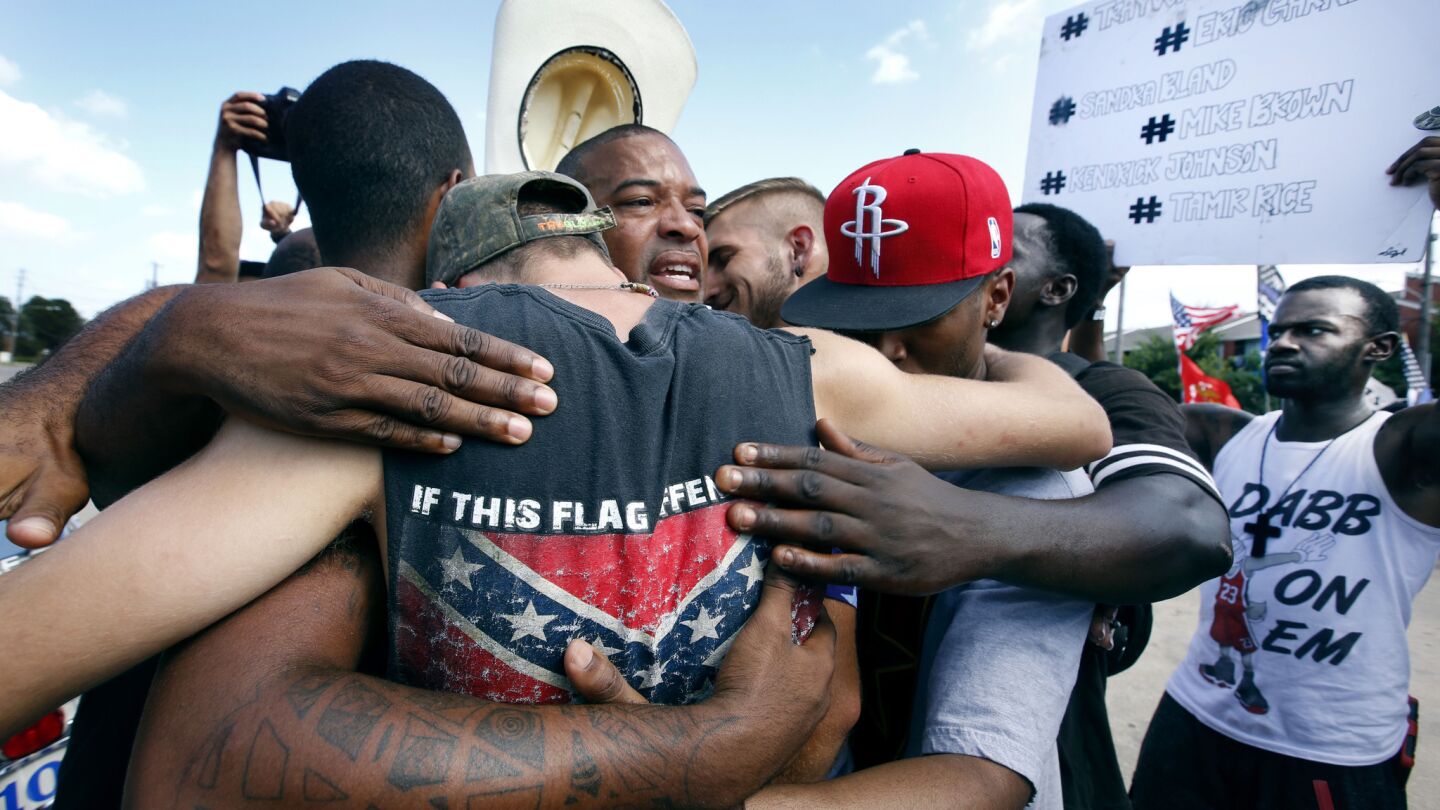 Black Lives Matter demonstrators share a group hug with All Lives Matter activists July 10 in Dallas.