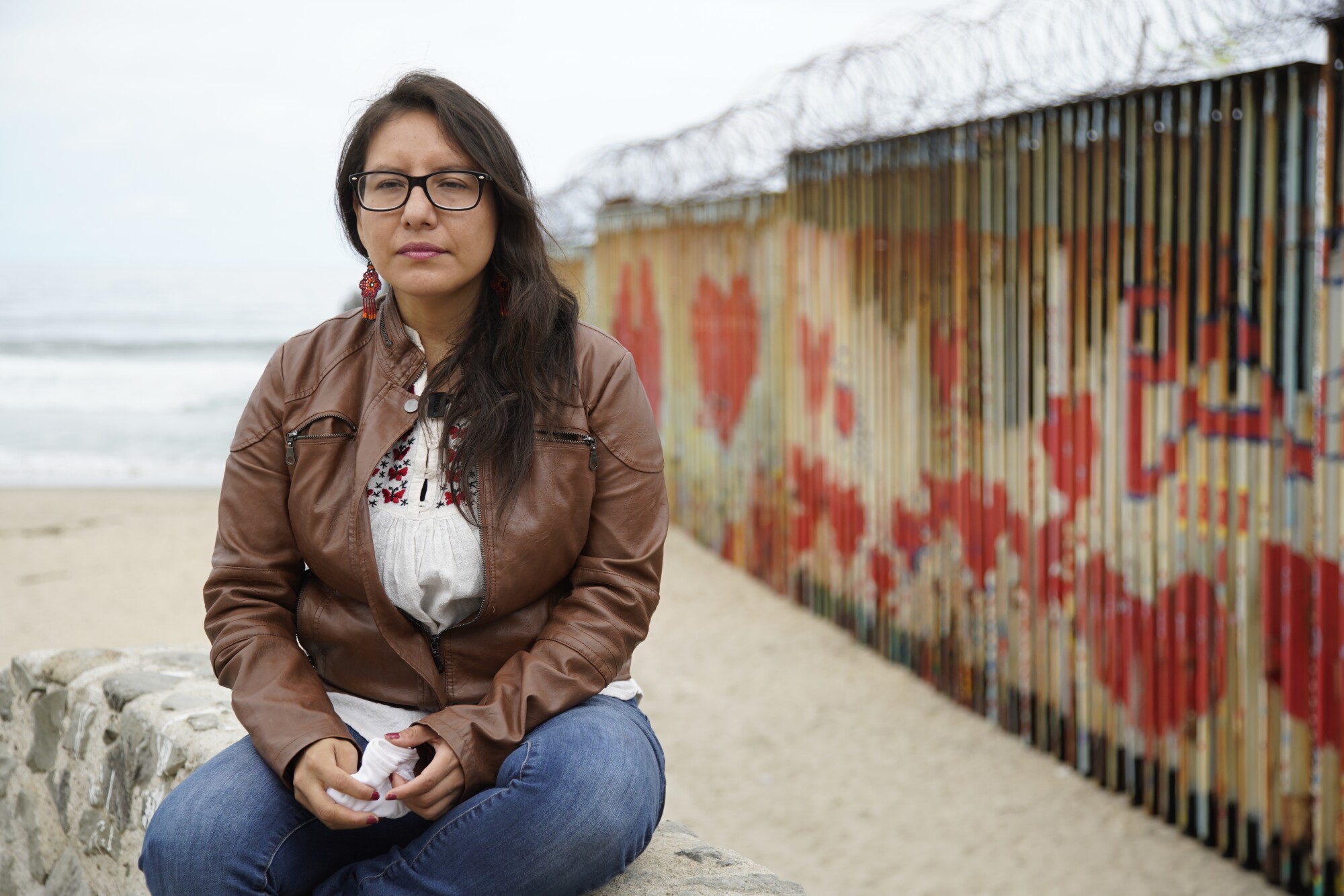 Dulce Garcia sits in front of the painted border fence