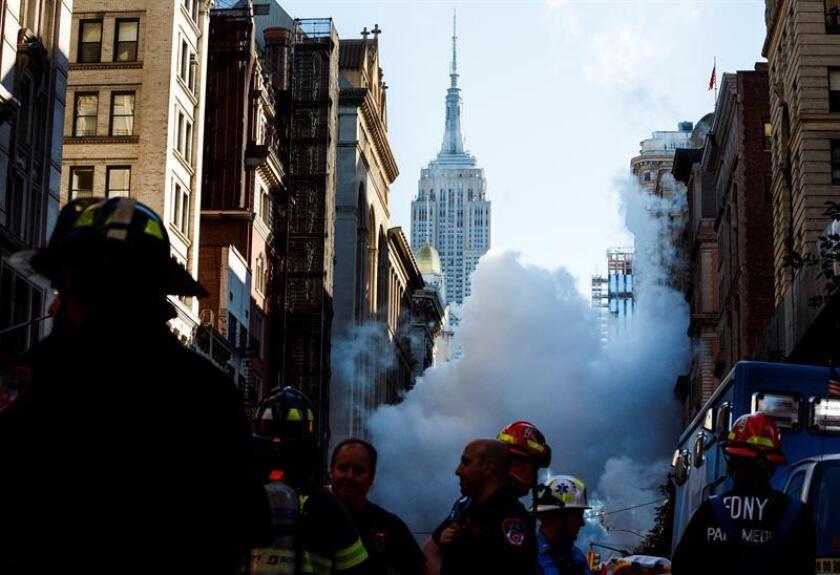 Varios bomberos trabajan en el lugar donde una tubería de vapor explotó en Manhattan, en la Quinta Avenida con la calle 21 Este, causando la evacuación de once edificios y cortes de tráfico desde la calle 19 hasta la 23 y entre La Sexta y Broadway, en Nueva York, EEUU, el 19 de julio del 2018. EFE