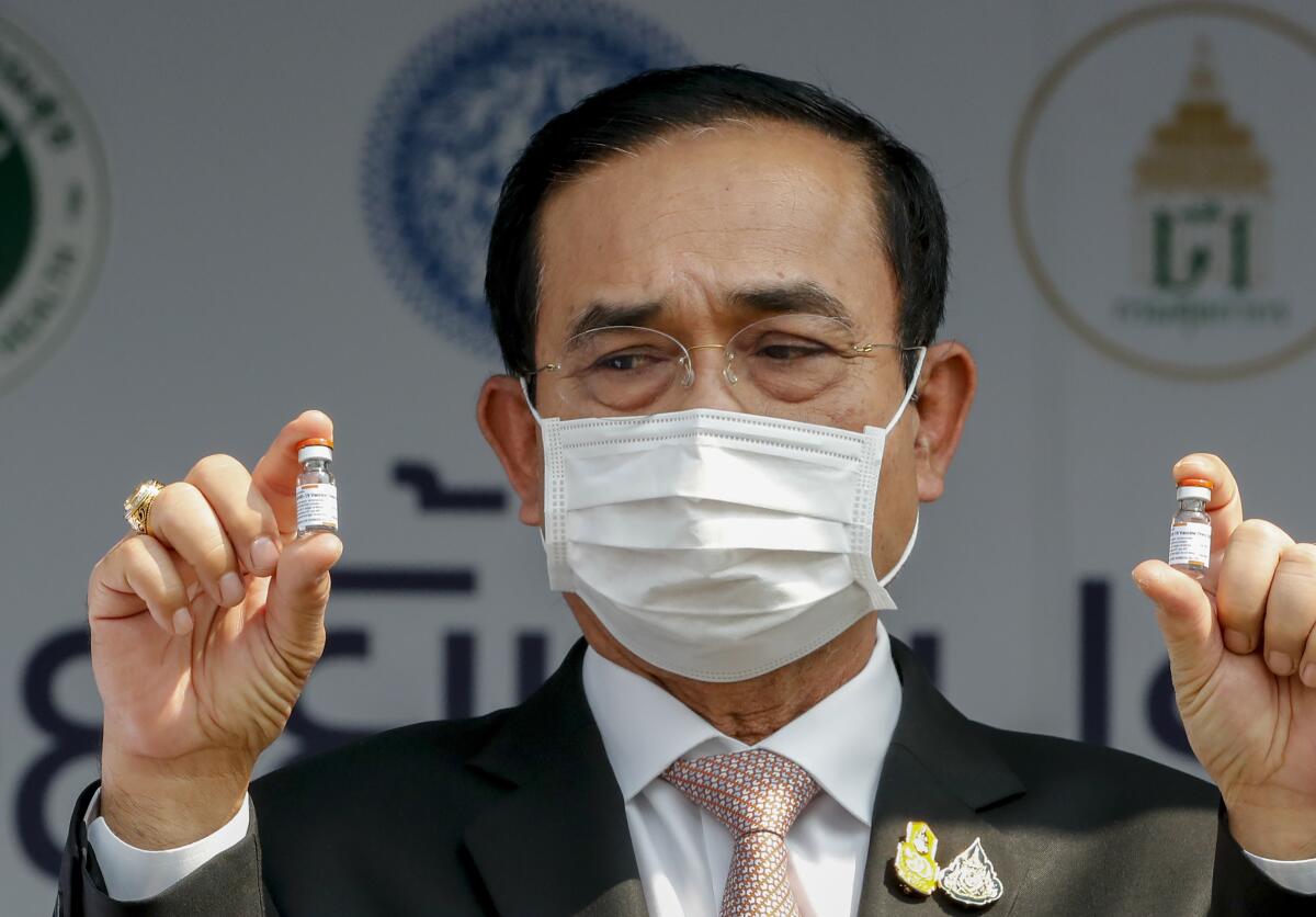 FILE - In this Feb. 24, 2021, file photo, Thai Prime Minister Prayuth Chan-ocha holds samples of Sinovac vaccine during a ceremony to mark the arrival of 200,000 doses of the Sinovac vaccine shipment at Suvarnabhumi airport in Bangkok, Thailand. Prayuth was not particularly lauded for his leadership last year against the coronavirus, but for much of 2020 Thailand fought the disease to a standstill, with low infection and death rates envied by more developed countries. (AP Photo/Sakchai Lalit, File)