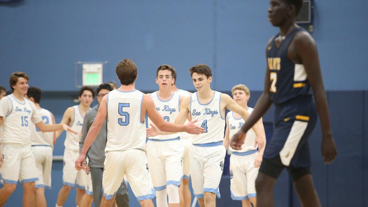 Corona del Mar High's players celebrate going into halftime with a 41-31 lead in a CdM Beach Bash opener against Crean Lutheran on Monday.