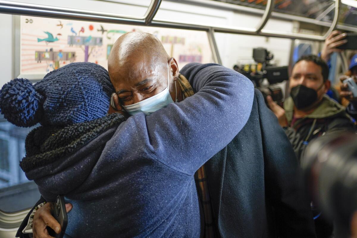 New York Mayor Eric Adams hugging a commuter on the subway