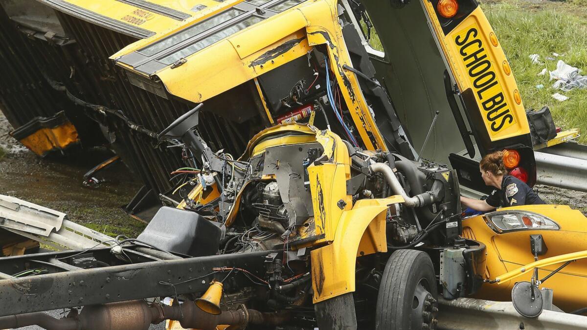 Emergency personnel examine a school bus after it collided with a dump truck on Interstate 80 in Mount Olive, N.J., Thursday, May 17, 2018.