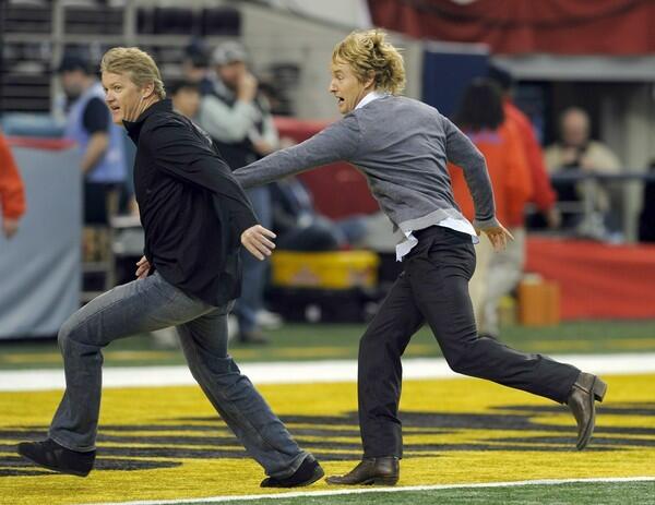 Actor Owen Wilson plays around on the field at Cowboys Stadium in Arlington, Texas before the start of Super Bowl XLV.