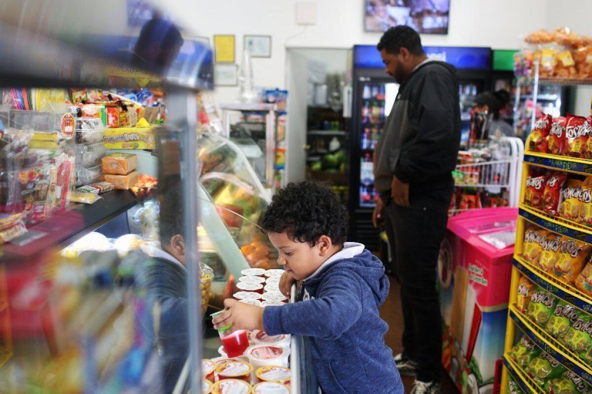 Legend Waring, left, chooses a jello with his father Jamaal Waring, right, at Noemi's Fruits, on Feb. 26.