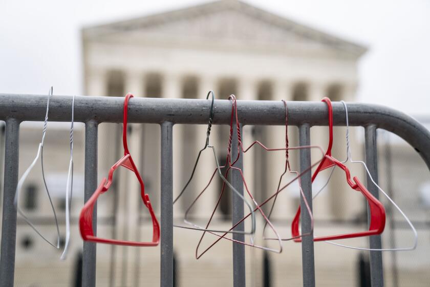 WASHINGTON, DC - MAY 14: Hangers are seen on a barricade as abortion rights activists participate in a Bans Off Our Bodies rally and march to the Supreme Court of the United States on Supreme Court of the United States on Saturday, May 14, 2022 in Washington, DC. Abortion rights supporters are holding rallies across the country urging lawmakers to codify abortion rights into law after a leaked draft from the Supreme Court revealed a potential decision to overturn the precedent set by landmark Roe v. Wade. (Kent Nishimura / Los Angeles Times)