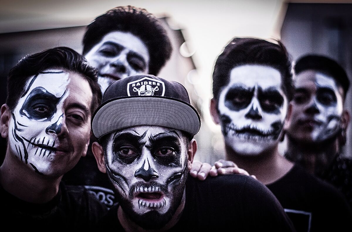black and white photo of five men in skeleton face makeup 