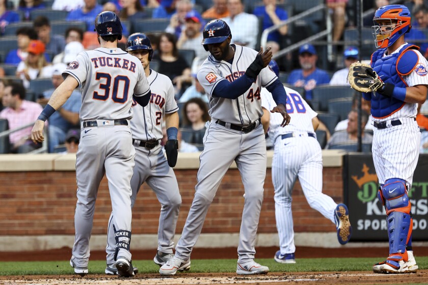 Houston Astros' Kyle Tucker (30) celebrates with Yordan Alvarez (44) andAlex Bregman (2), as New York Mets catcher James McCann waits after Tucker hits a three-run home run during the first inning of a baseball game Tuesday, June 28, 2022, in New York. (AP Photo/Jessie Alcheh)