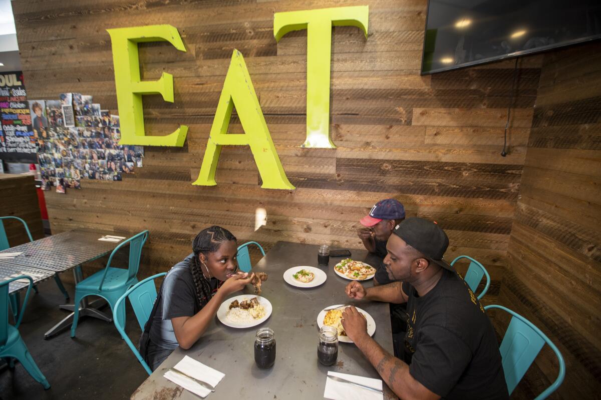 Shanae Hilt, left, Winston Thomas and Travion Griffin dine at No Reservations L.A.