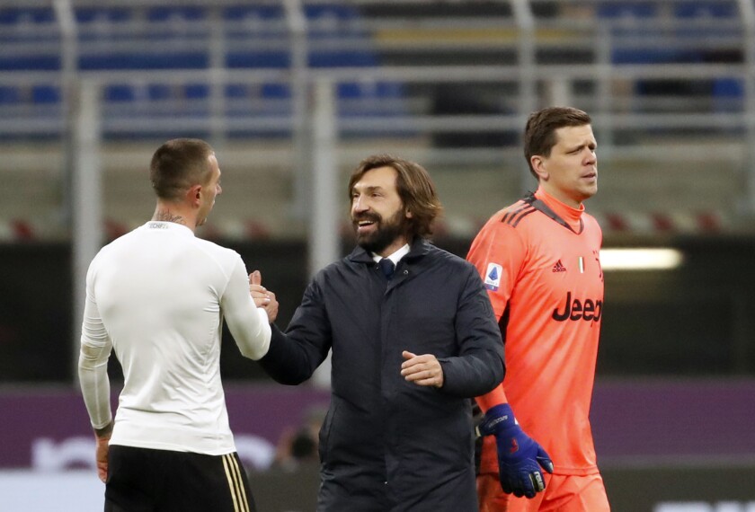 Juventus' head coach Andrea Pirlo, centre, shakes hands with Juventus' Federico Bernardeschi at the end of the Serie A soccer match between AC Milan and Juventus at the San Siro stadium, in Milan, Italy, Wednesday, Jan. 6, 2021. (AP Photo/Antonio Calanni)