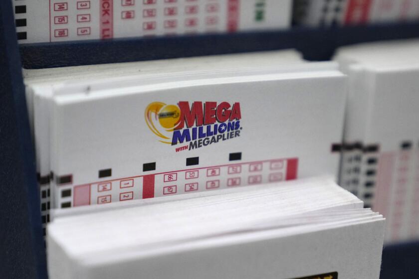 FILE - A display holds Mega Million lottery ticket wagering cards at Ted's State Line Mobil station, Thursday, Jan. 5, 2023, in Methuen, Mass. An estimated $1.1 billion Mega Millions jackpot drawing Tuesday, Jan. 10, 2023, has people lined up at convenience stores nationwide to buy tickets in longshot hopes of winning a massive prize, but shop and gas station owners selling the tickets also have a chance at a big-figure bonus. (AP Photo/Charles Krupa, File)
