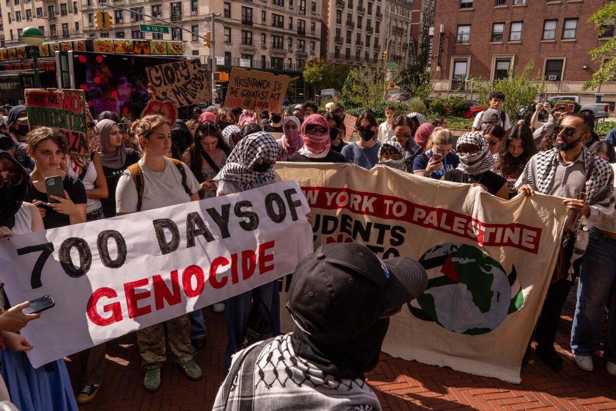 Students hold banners reading "700 Days of Genocide" and other messages.