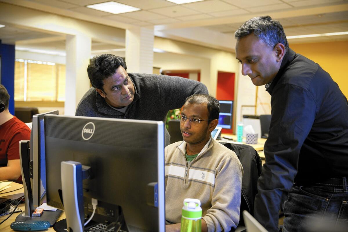 Urban Engines co-founder Balaji Prabhakar, left, and chief executive Shiva Shivakumar, right, discuss code changes with Deepak Merugu in Los Altos.
