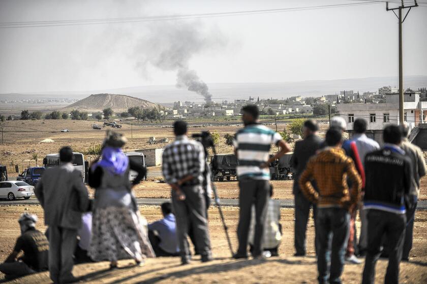 Smoke rises from the Syrian city of Kobani, seen from near the Mursitpinar crossing on the Turkish-Syrian border.