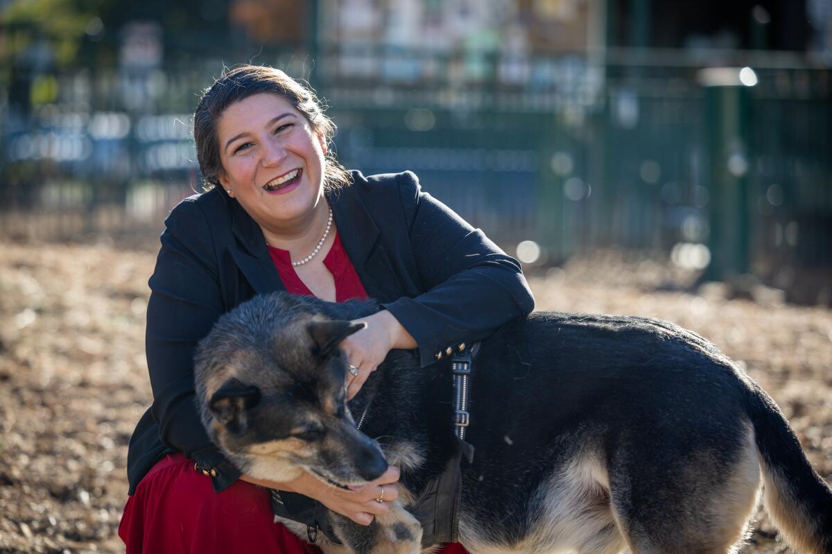 A woman holds a dog.