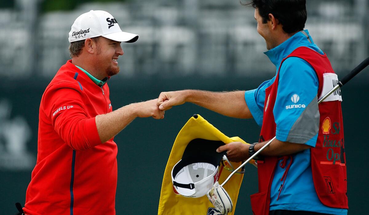 J.B. Holmes is congratulated by his caddie after winning the Houston Open on Sunday.