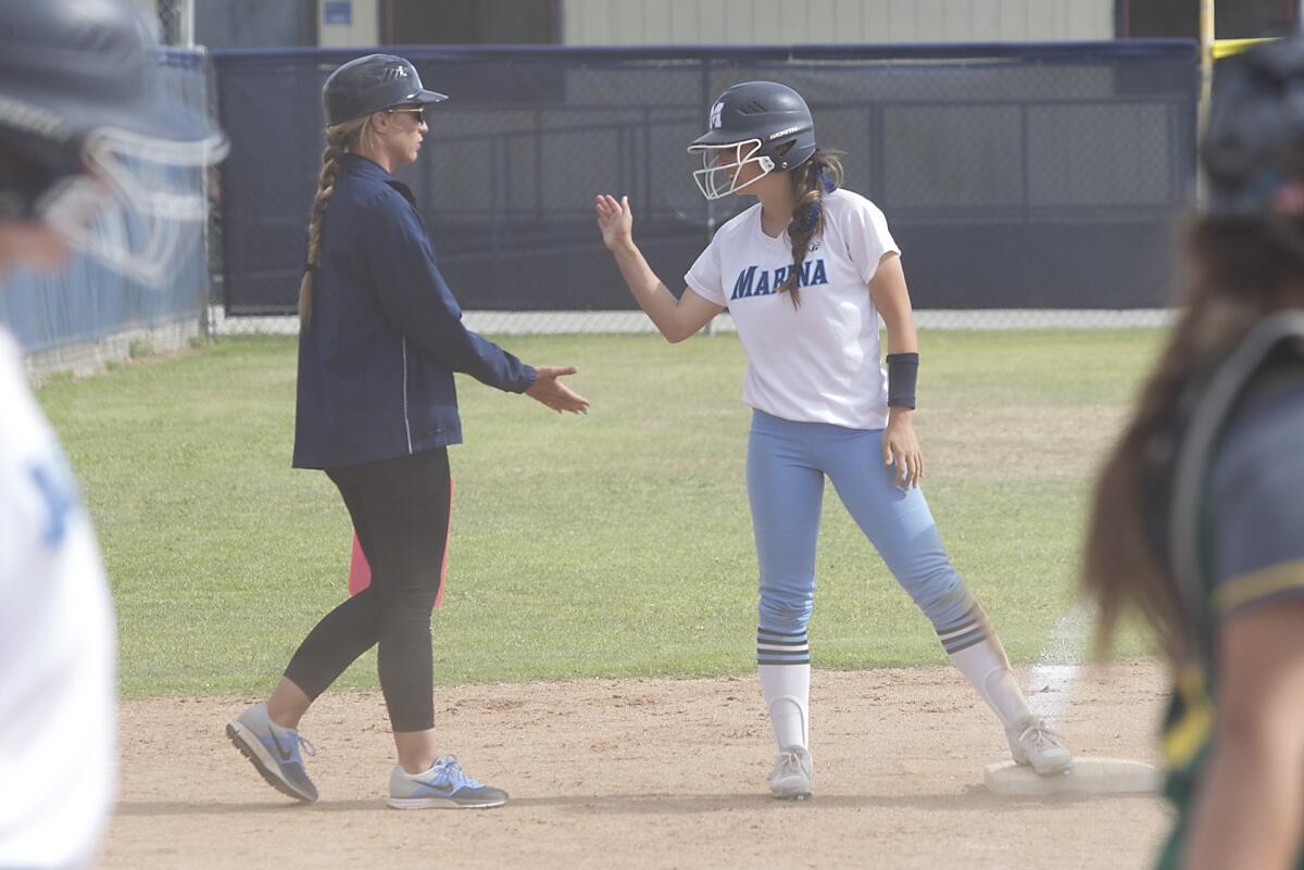 Marina coach Mandee Farish, left, congratulates Marina's Malia Temple after she hit a triple against Edison at Marina High.