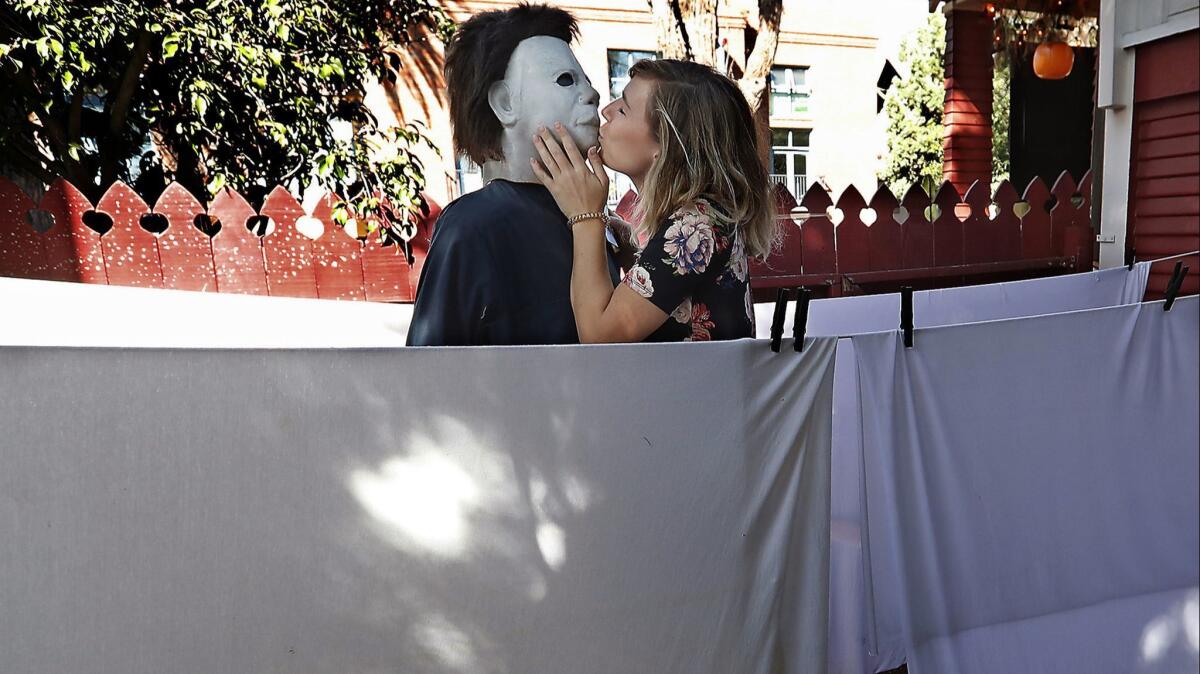 Jordan Hafford of Salt Lake City kisses a mannequin of villain Michael Myers that is part of a re-created scene from the 1978 movie "Halloween."